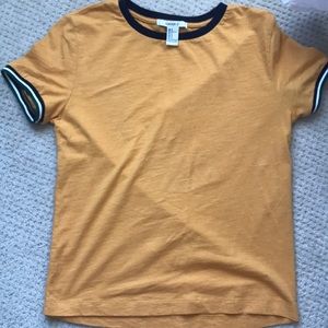 A mustard type colored tee-shirt.